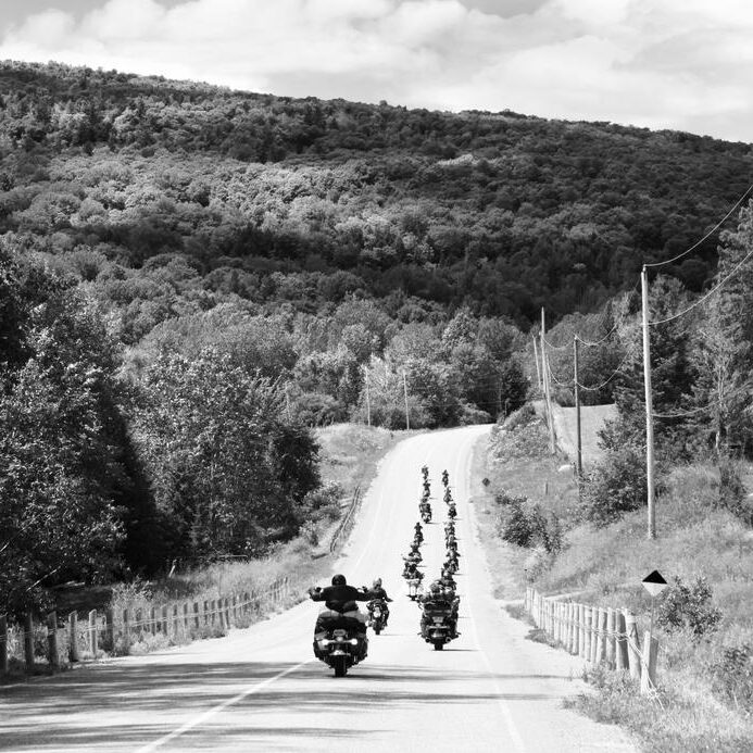 motorcycle-caravan-rides-hillside-in-black-and-white
